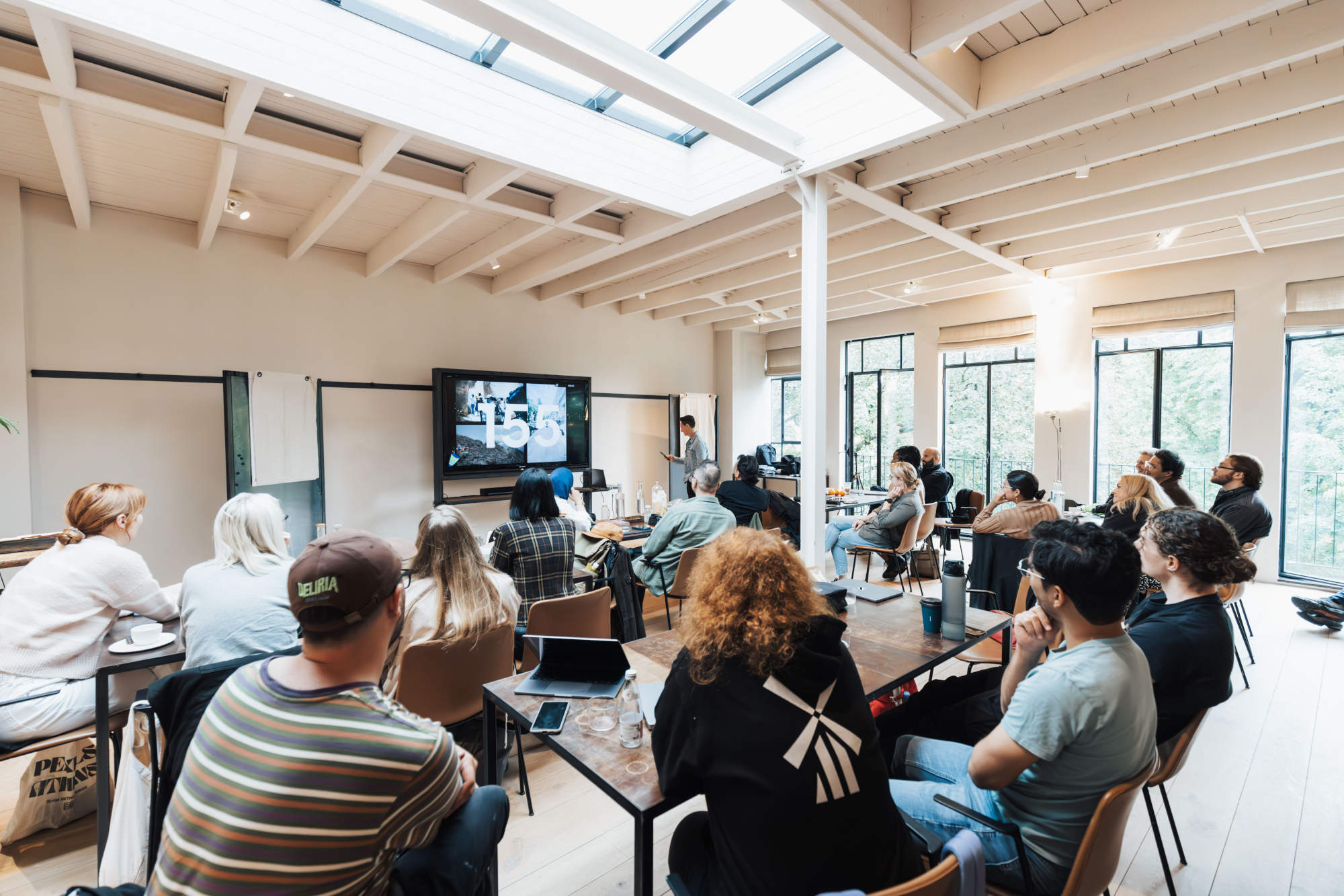 A team gathered around a screen during an all-staff meeting.