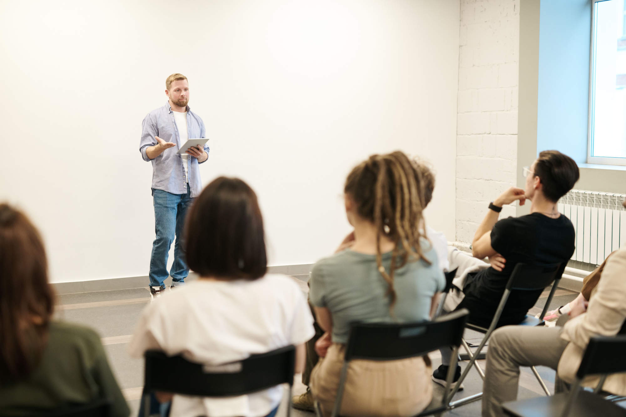 A presenter speaking to a seated group during a team session.